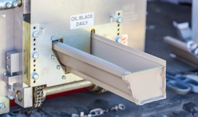 Seamless gutter being formed on-site by a gutter machine