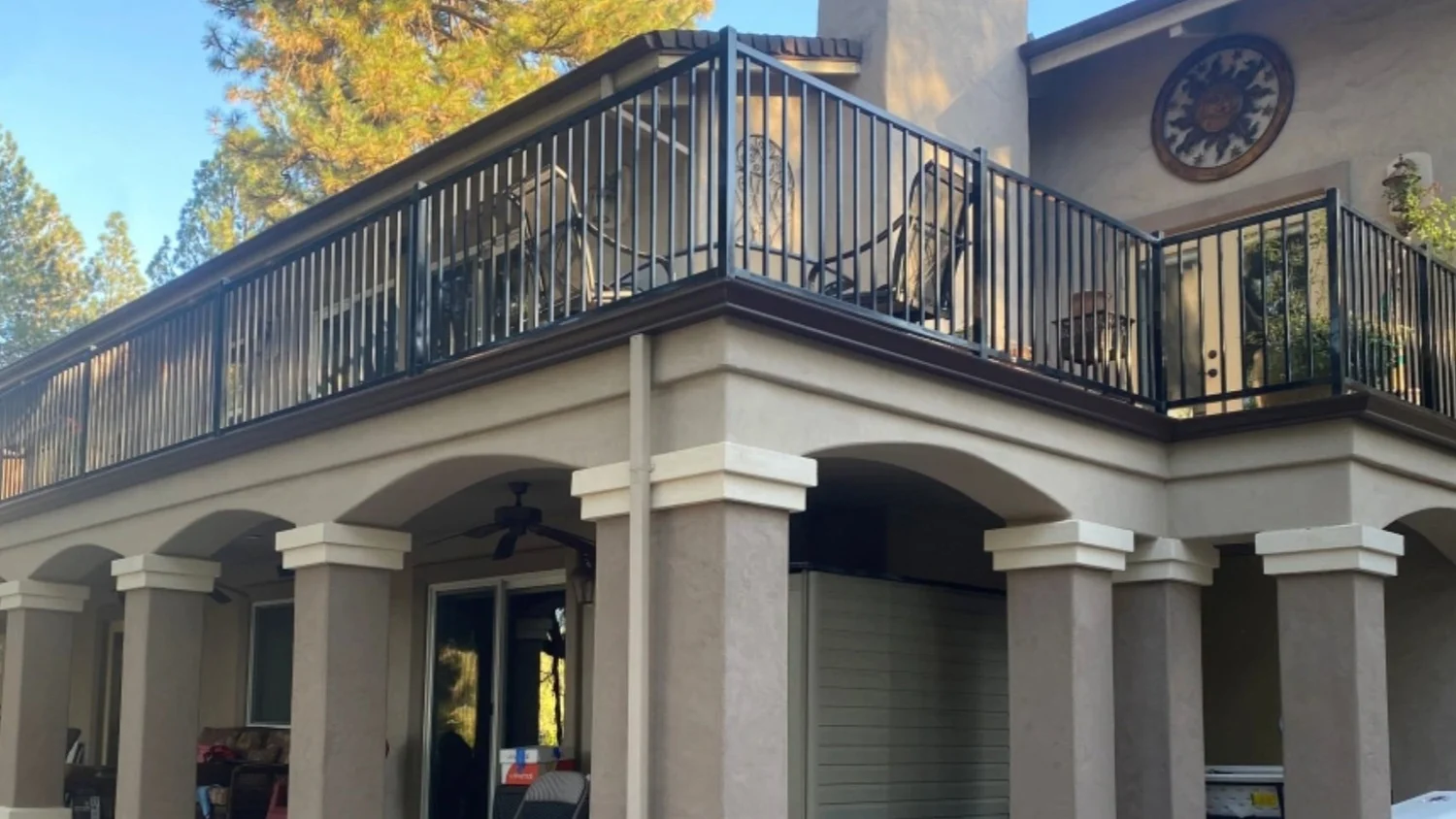 Dark brown gutters installed on a two-story stucco home